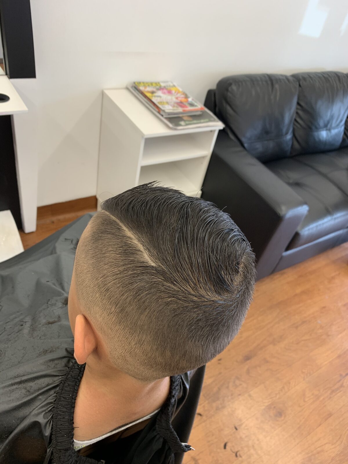 A finished side-part haircut with a faded back and sides